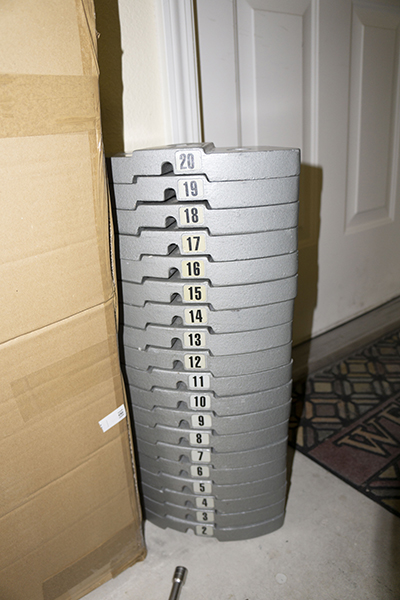 Photograph showing Hoist Fitness V5 vertical gym weight stack plates after they are removed, so as to move the gym.